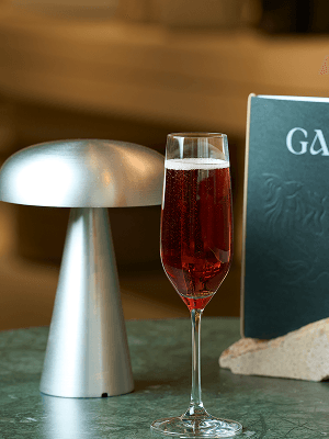 Champagne flute beside a Gaia menu on a marble table