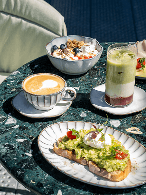 Brunch spread with coffee, granola and matcha on a marble table